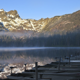 Fog on sardine lake and boats with sierra buttes mountains california